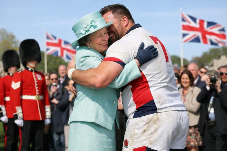 la princesse anne surprend en offrant une accolade chaleureuse à un joueur de rugby, après un premier refus, marquant un geste inattendu et touchant.